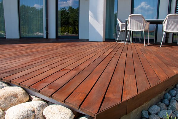 A small deck surrounded by rocks with outdoor furniture in the background.