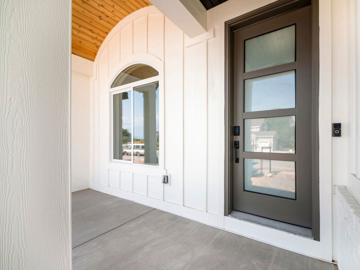 A front door with board and batten siding around the door