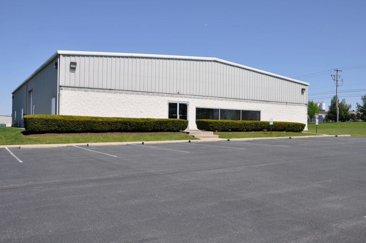 The front of a commercial building with a parking lot.