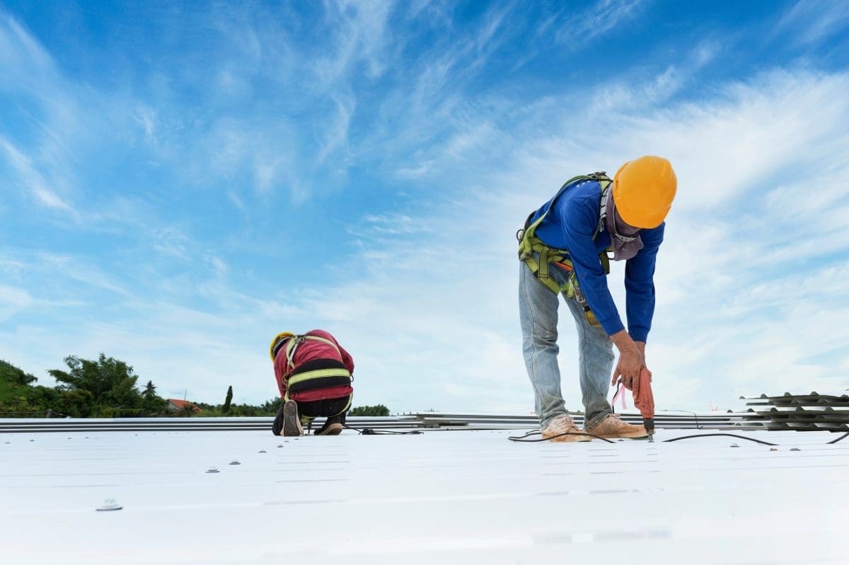 Commercial roofers performing repairs on a roof.