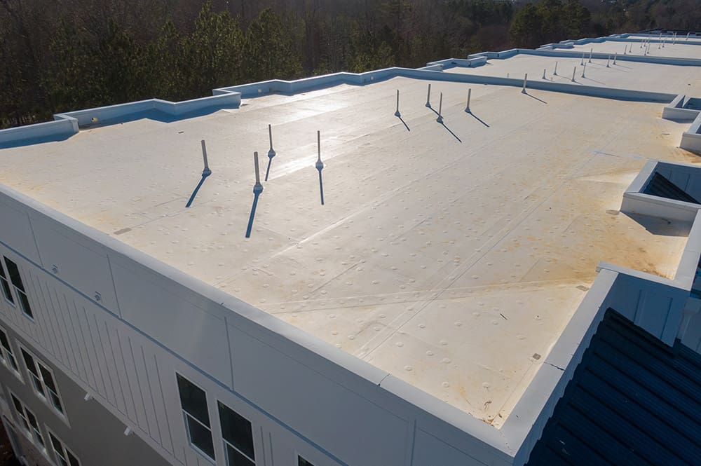 An overhead view of a new white roof on a commercial building