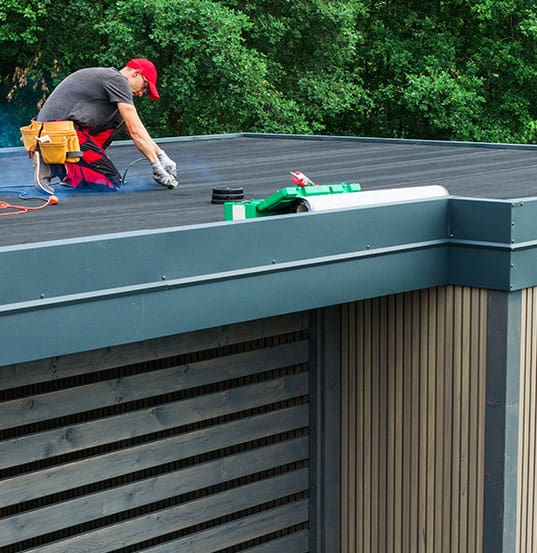 Skilled Worker Performing Maintenance on a Modern Flat Roof